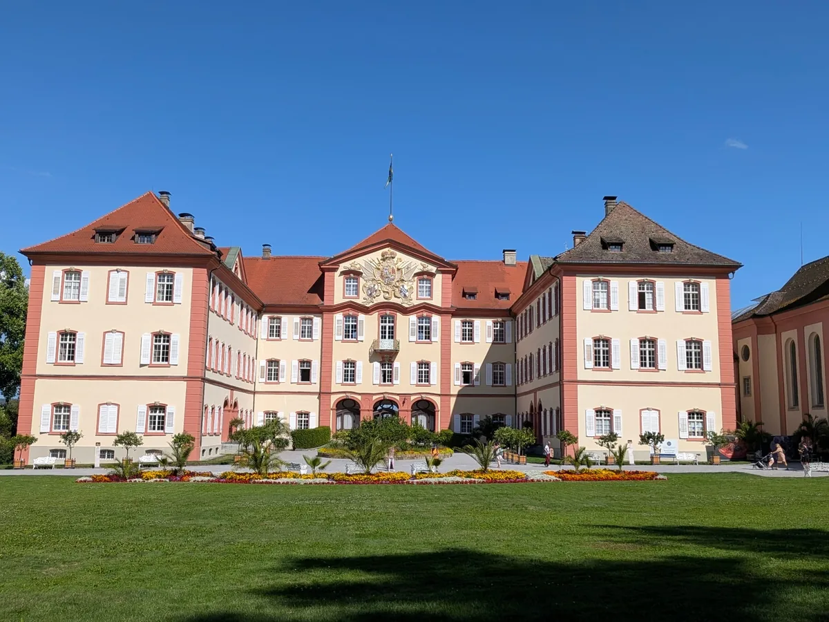 Schloss Mainau mit heller Fassade, rotem Dach und vorgelagerter Rasenfläche