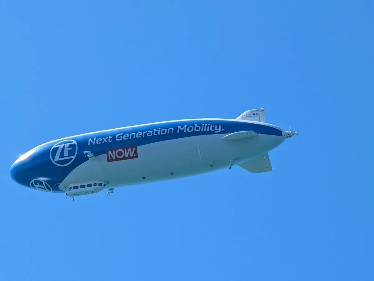 Ein Zeppelin fliegt vor blauem Himmel über der Bodenseeregion