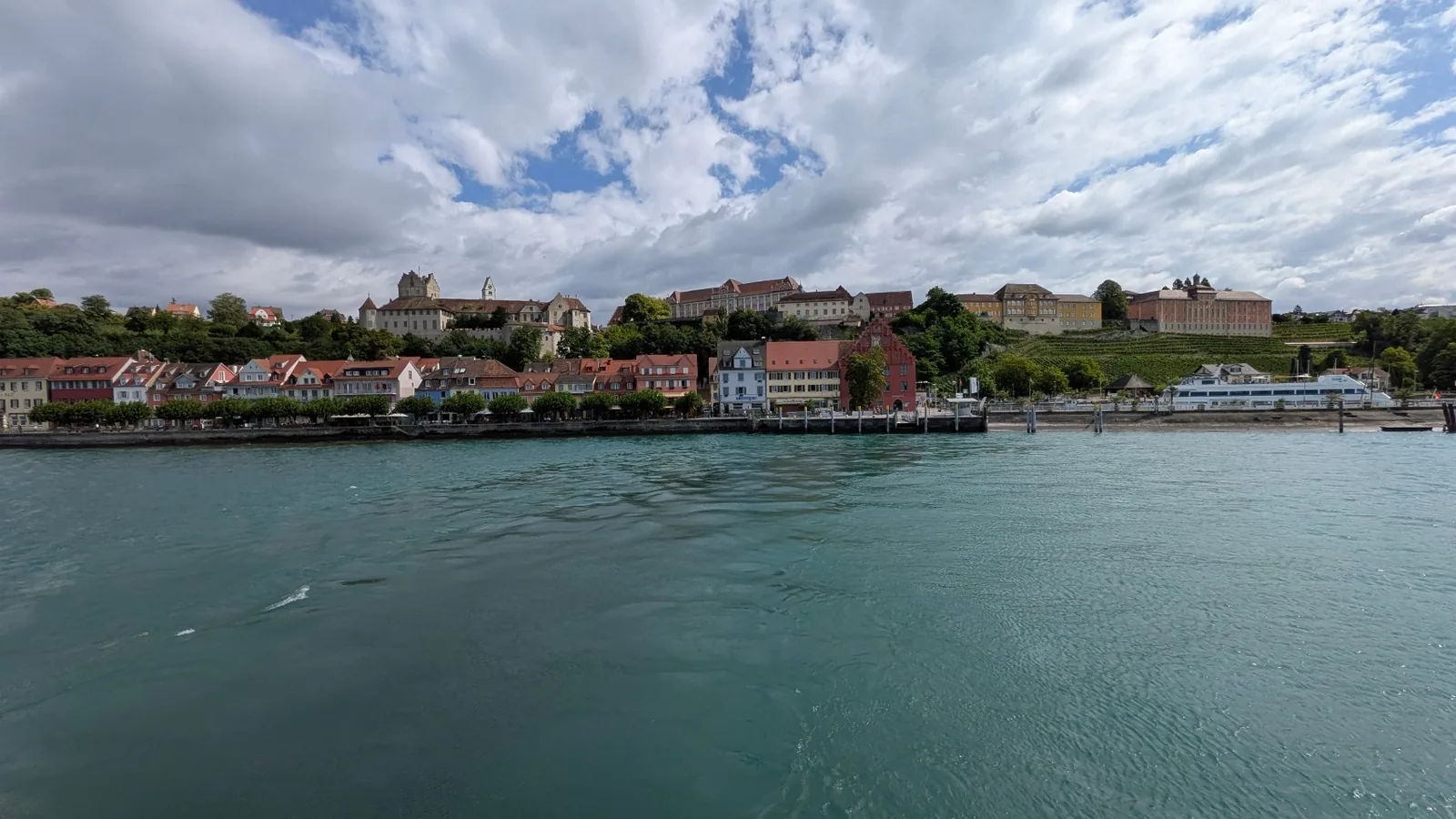 Blick über den Bodensee auf Meersburg unter einem weit geöffneten Wolkenhimmel
