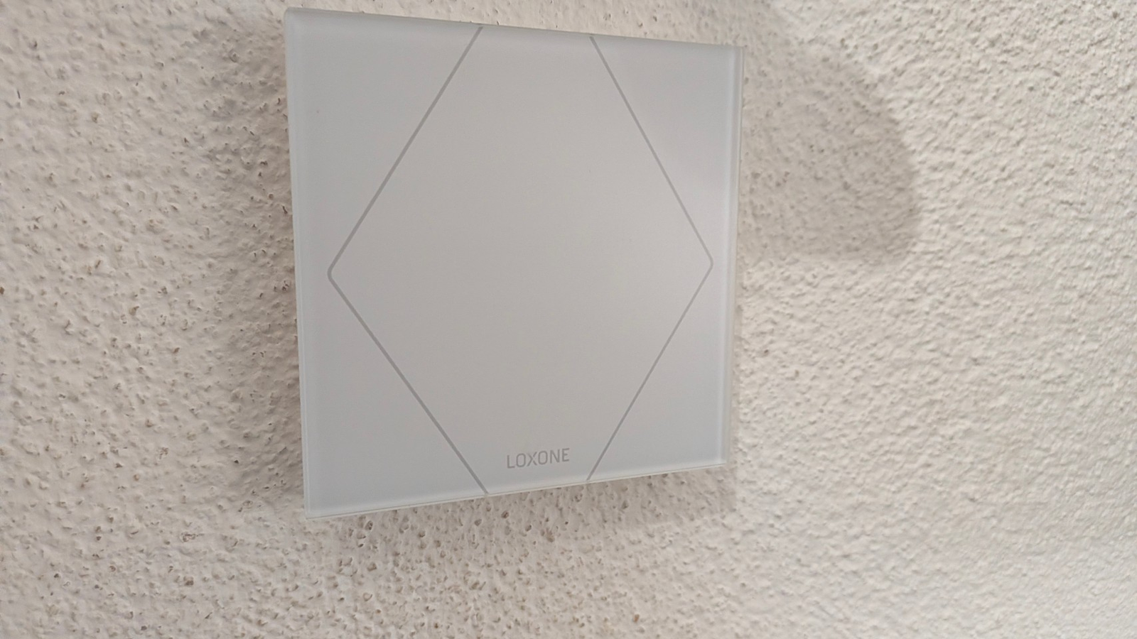 Weisser Loxone-Taster an einer hellen Innenwand