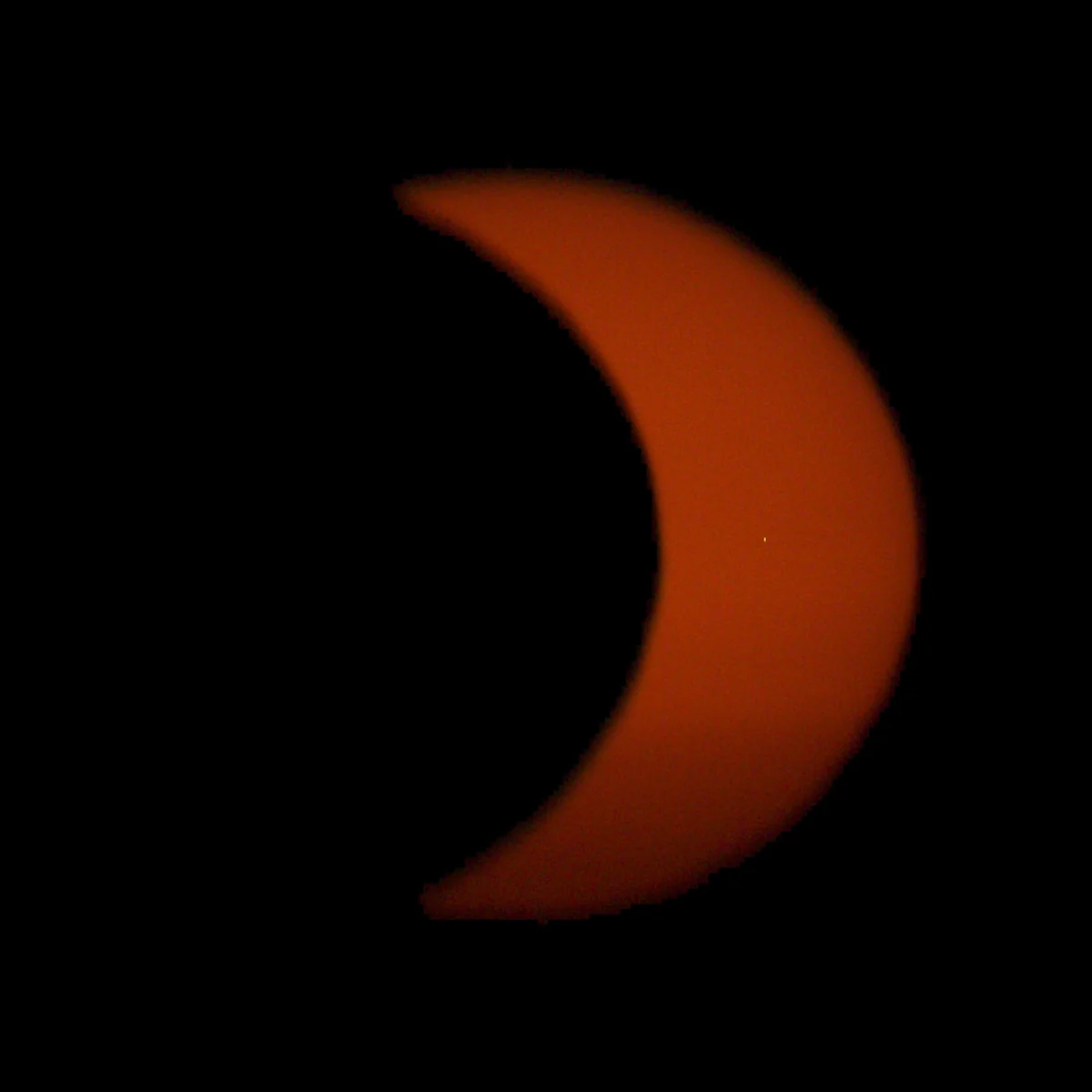 Warme orange-rote Sonnensichel in einer späten Phase der Finsternis